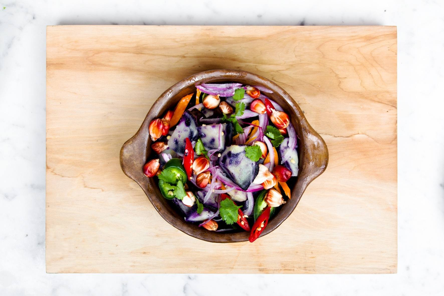 Over the top wooden bowl with colorful mixed veggie salad.